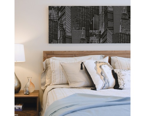 Schlafzimmer mit Bett, Nachttisch und Wandbild