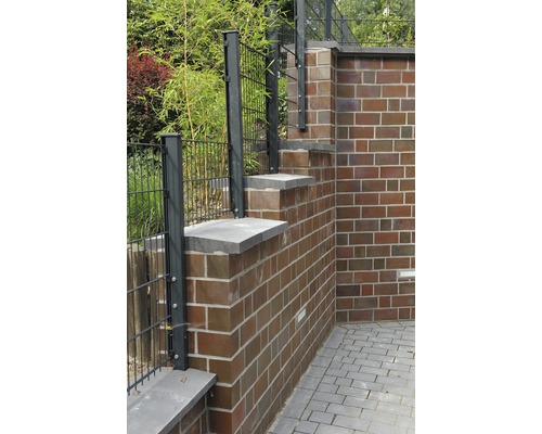 Außenansicht eines Gartens mit Zaun und Backsteinmauer