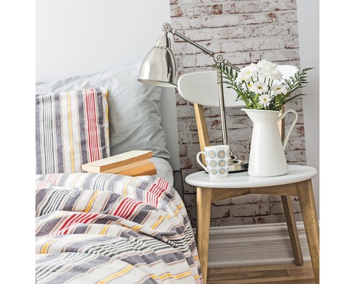 Dekoratives Schlafzimmer mit Bett, Nachttisch, Lampe und Blumen