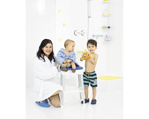 Badezimmer Szene mit Mutter, Kind auf Duschhocker und älterem Kind mit Badespielzeug.