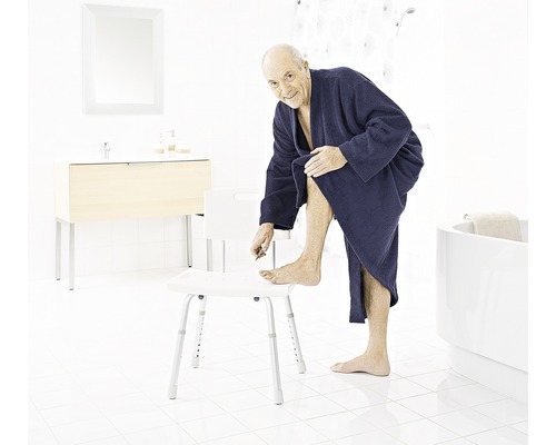 Ein Mann in einem Badezimmer benutzt einen Duschstuhl.