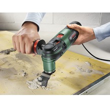 Oszillierendes Multifunktionswerkzeug beim Entfernen von Material von einem Holzbrett.
