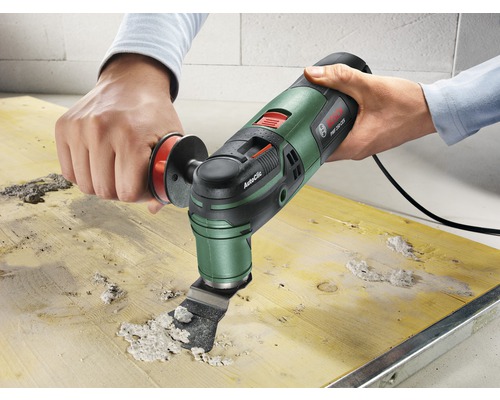 Oszillierendes Multifunktionswerkzeug beim Entfernen von Material von einem Holzbrett.