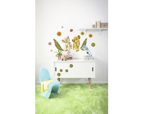 Raumdekoration mit Wandtattoos von zwei Löwenfiguren, Kreisen und Blättern über einem Schrank mit Pfotenabdruckaufklebern.