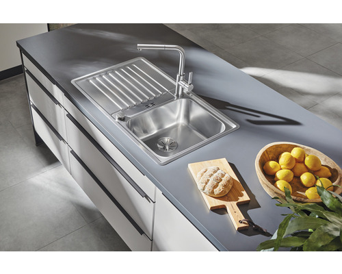 Edelstahlspüle mit Abtropffläche und Armatur auf einer Küchentheke