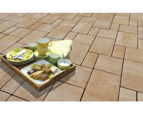 Terrasse mit Betonpflastersteinen und Tablett mit Geschirr und Gebäck