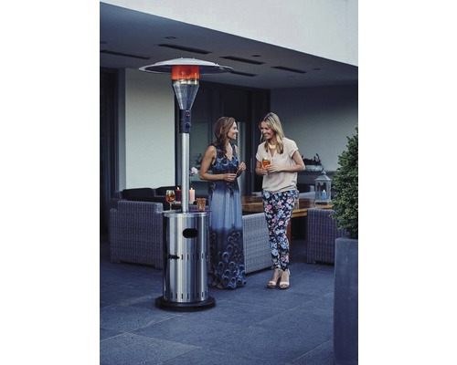 Zwei Frauen stehen neben einem Edelstahl-Terrassenheizer auf einer Terrasse