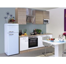 Küchenszene mit Einbauküche, Kühlschrank, Esstisch und Stühlen in einem hellen Raum.