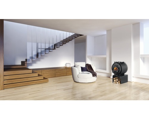 Wohnzimmer mit Holztreppe, Sessel und Kaminofen