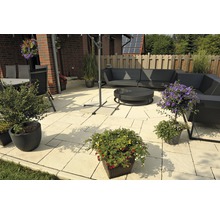 Terrasse mit Gartenmöbeln, Sonnenschirm und Pflanzenkübeln