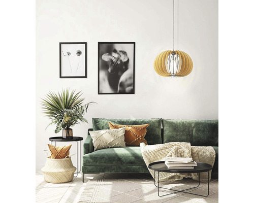 Wohnzimmer mit grünem Sofa, Couchtisch, Hängelampe und dekorativen Elementen