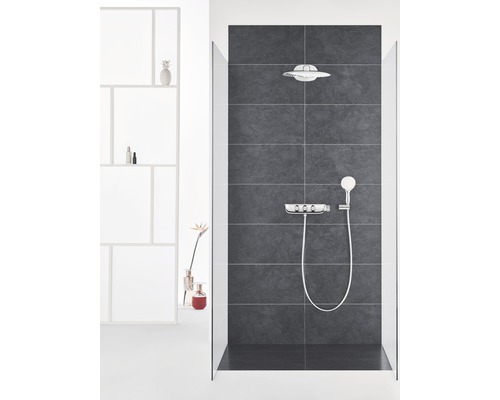 Badezimmer mit Dusche, Kopfbrause, Handbrause und Armatur vor dunklem Fliesenspiegel