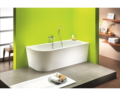 Badezimmer mit Badewanne, Armatur und Ablageflächen für Badutensilien