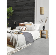 Schlafzimmer mit Holzwand, Bett, Kissen, Decken, Beistelltisch und Lampe