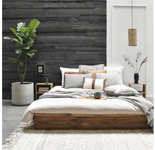 Schlafzimmer mit Bett, Nachttischen, Wandpaneelen und Zimmerpflanze