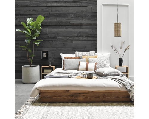 Schlafzimmer mit Bett, Nachttischen, Wandpaneelen und Zimmerpflanze