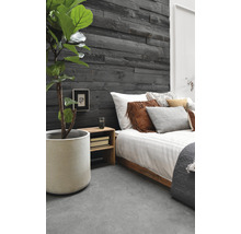 Schlafzimmer mit Holzwandpaneelen, Bett und Zimmerpflanze im Topf.