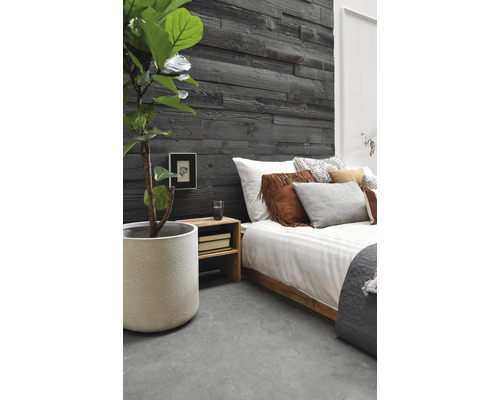 Schlafzimmer mit Holzwandpaneelen, Bett und Zimmerpflanze im Topf.