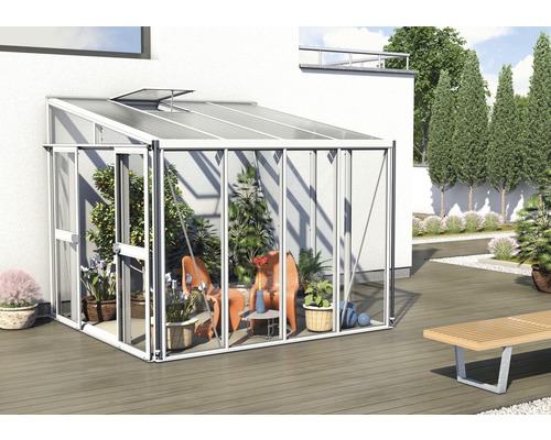 Gewächshaus mit Pflanzen und Sitzgelegenheiten im Garten