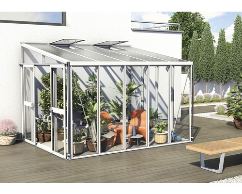 Gewächshaus mit Pflanzen und Sitzgelegenheiten im Garten.