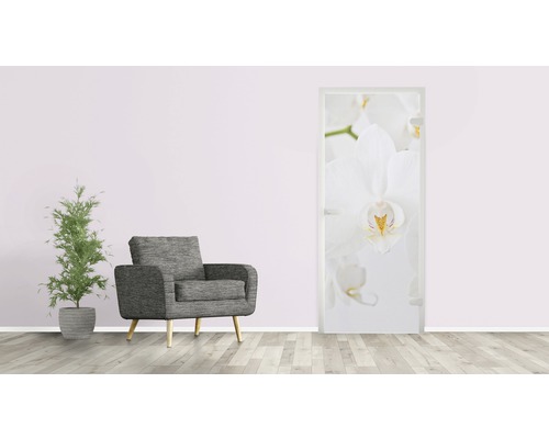 Dekoratives Türposter mit Orchideenmotiv in einem Wohnraum mit Sessel und Pflanze.
