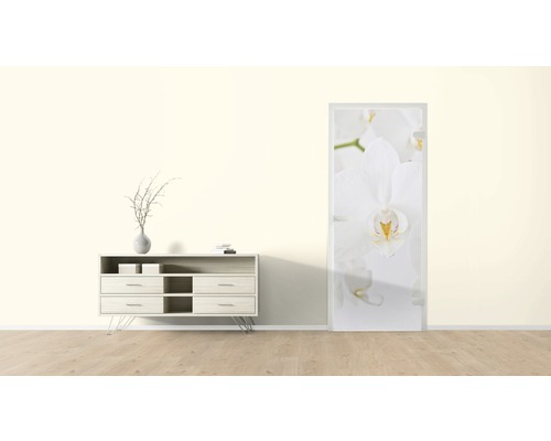 Heller Raum mit Kommode und Türposter mit Orchideenmotiv