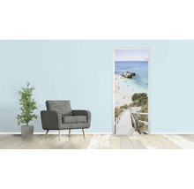 Wohnzimmer mit Sessel, Zimmerpflanze und Türposter mit Strandmotiv