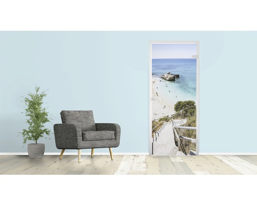 Wohnzimmer mit Sessel, Zimmerpflanze und Türposter mit Strandmotiv