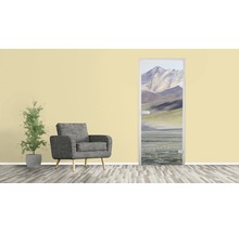 Wohnzimmer mit Sessel, Pflanze und Türposter mit Bergmotiv