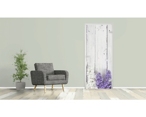 Szene mit einem Sessel, einer Zimmerpflanze und einer Tür mit Blumenmotiv