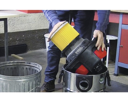 Person entsorgt Filter eines Staubsaugers in einem Mülleimer