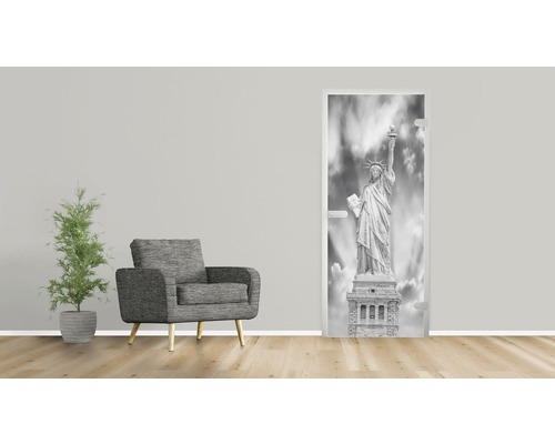 Wohnraum mit Sessel, Zimmerpflanze und Türposter Freiheitsstatue