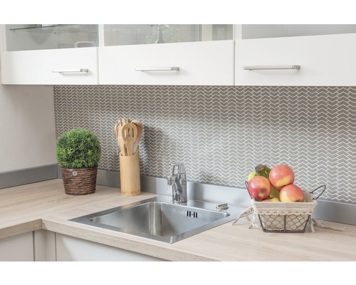 Küchenspüle mit Armatur, Holzzubehör und Dekoration auf einer hellen Arbeitsplatte