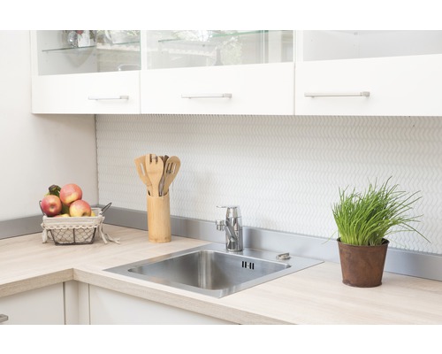 Küchenspüle mit Armatur und Utensilien auf einer hellen Arbeitsplatte