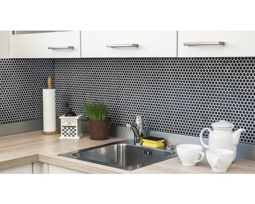Küchenszene mit Spüle, Armatur, Mosaikfliesen und Küchenutensilien auf der Arbeitsfläche.