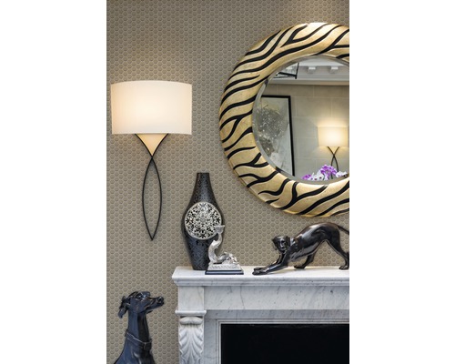 Dekorativer Kamin mit Spiegel, Lampe und dekorativen Figuren auf einem Mosaikhintergrund.