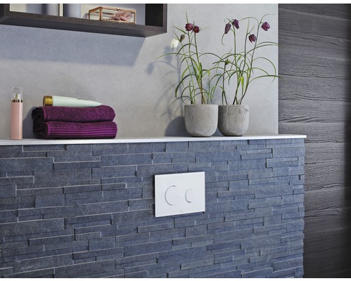 Badezimmergestaltung mit grauer Steinwand, Ablage mit Handtüchern und Pflanzen