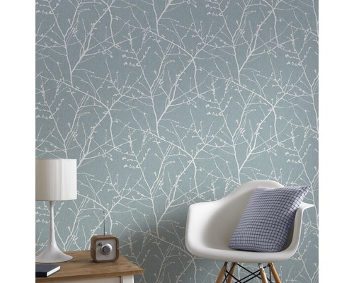 Wohnraum mit hellblau gemusterter Tapete, Stuhl, Tischleuchte und Radio