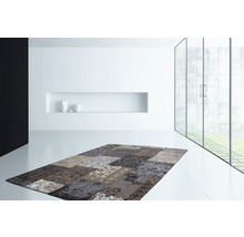 Moderner Wohnraum mit Patchwork-Teppich in verschiedenen Mustern und Texturen.