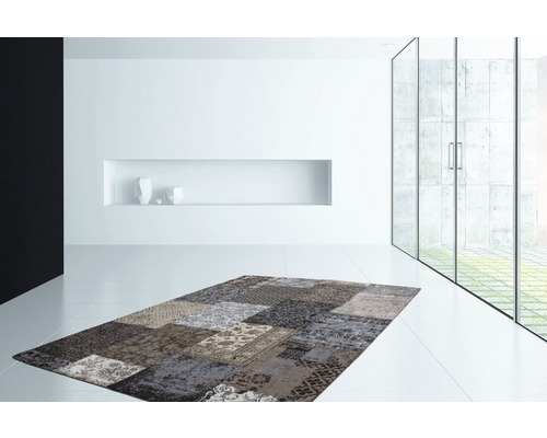 Moderner Wohnraum mit Patchwork-Teppich in verschiedenen Mustern und Texturen.