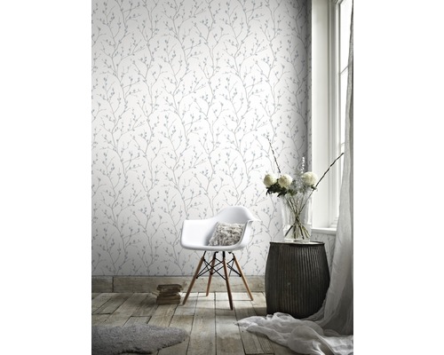 Heller Raum mit gemusterter Tapete, Stuhl und Beistelltisch.