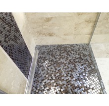 Detailansicht einer Dusche mit Mosaikfliesen auf dem Boden und einer Akzentwand