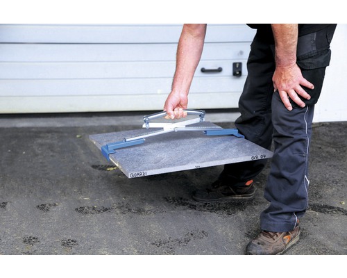 Mann trägt Fliese mit Fliesentragehilfe