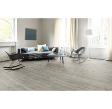 Heller Wohnraum mit Laminatboden, Sofa und zwei Schaukelstühlen.