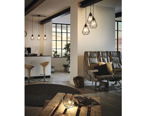 Wohnzimmer mit Sitzgelegenheiten, Stehtisch und mehreren Pendelleuchten mit Drahtschirm