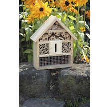 Insektenhotel aus Holz mit verschiedenen Füllmaterialien vor gelben Blumen