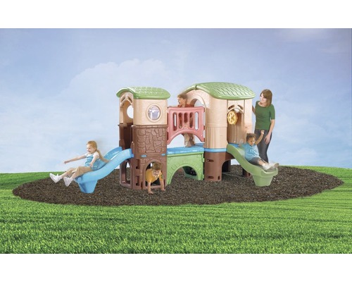 Spielturm Step2 Clubhouse Climber Kunststoff mit Rutsche blau Kinderspielhaus mit Rutschen auf einer Rasenfläche mit Kindern und einer erwachsenen Person