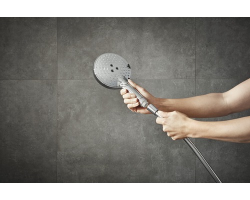 Handbrause mit Brauseschlauch vor Fliesenwand