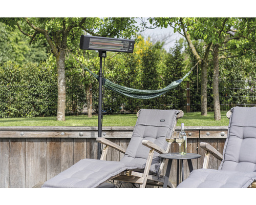 Terrassenszene mit Heizstrahler auf Stativ und Liegestühlen im Garten.