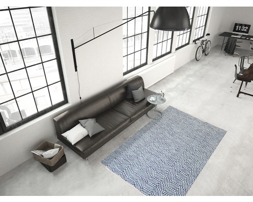 Wohnzimmer mit Sofa, Teppich und großem Fenster